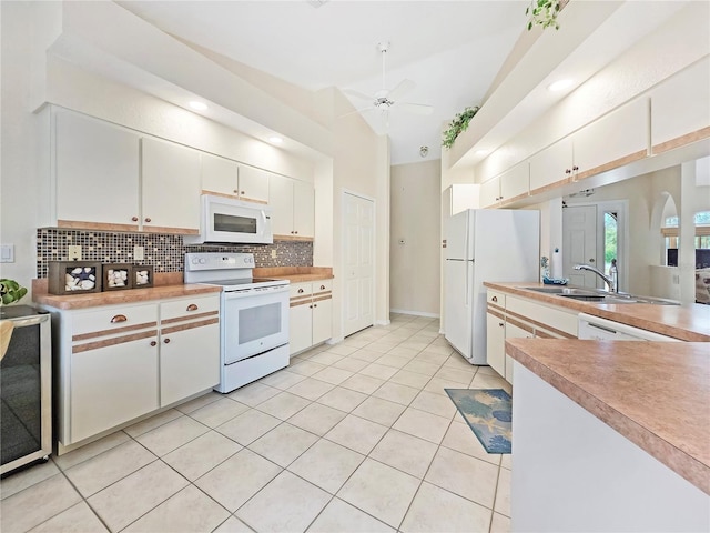 18395 Edgewater Dr, Port Charlotte, FL 33948 - kitchen featuring decorative backsplash, beverage cooler, white appliances, white cabinets, and ceiling fan
