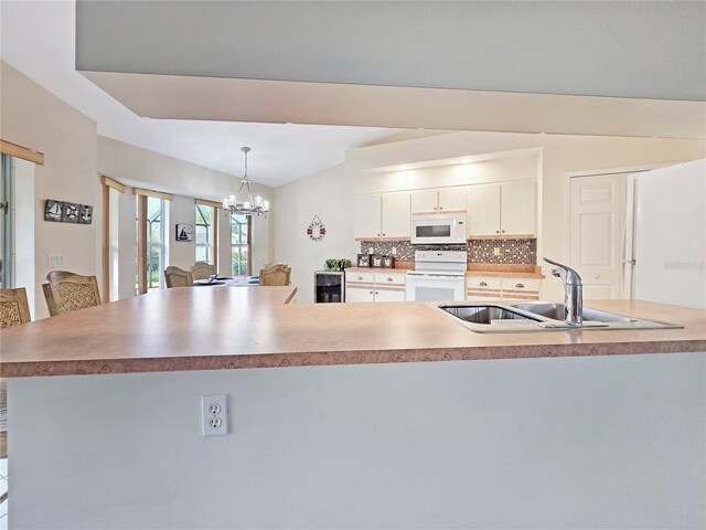18395 Edgewater Dr, Port Charlotte, FL 33948 - kitchen featuring white appliances, decorative backsplash, hanging light fixtures, a sink, and a notable chandelier