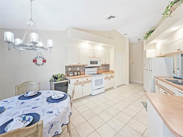 18395 Edgewater Dr, Port Charlotte, FL 33948 - kitchen featuring vaulted ceiling, light countertops, a ceiling fan, white appliances, and decorative backsplash
