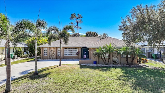 18395 Edgewater Dr, Port Charlotte, FL 33948 - view of front facade featuring stucco siding, driveway, roof with shingles, and a front yard