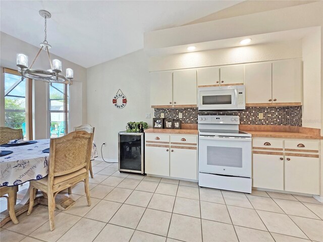 18395 Edgewater Dr, Port Charlotte, FL 33948 - kitchen featuring decorative backsplash, a chandelier, white appliances, beverage cooler, and vaulted ceiling