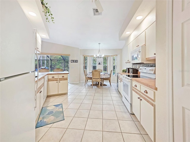 18395 Edgewater Dr, Port Charlotte, FL 33948 - kitchen with light countertops, pendant lighting, light tile patterned floors, white appliances, and visible vents