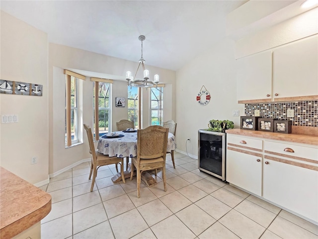 18395 Edgewater Dr, Port Charlotte, FL 33948 - dining space featuring light tile patterned flooring, baseboards, wine cooler, and an inviting chandelier
