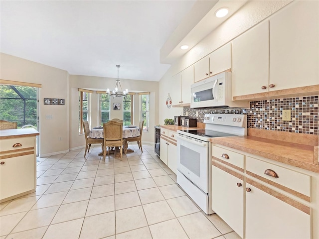 18395 Edgewater Dr, Port Charlotte, FL 33948 - kitchen with light countertops, white appliances, a chandelier, decorative backsplash, and light tile patterned flooring