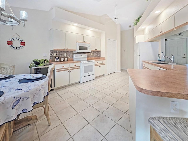 18395 Edgewater Dr, Port Charlotte, FL 33948 - kitchen with a sink, tasteful backsplash, lofted ceiling, light tile patterned floors, and white appliances