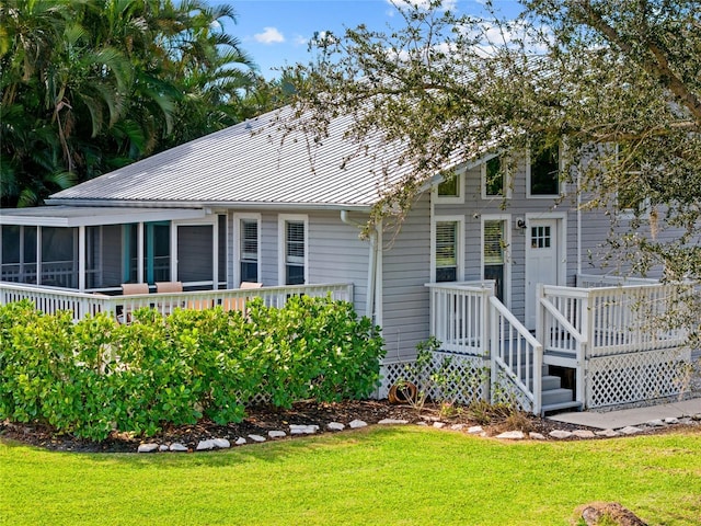 exterior space with a sunroom and a lawn