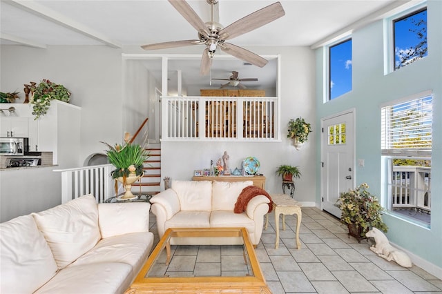 tiled living room with a towering ceiling and beam ceiling