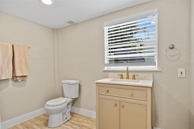 bathroom with vanity, hardwood / wood-style flooring, and toilet