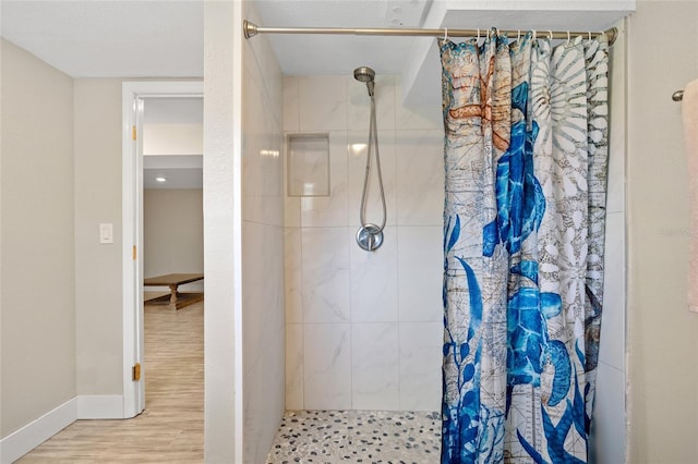 bathroom with walk in shower and hardwood / wood-style floors