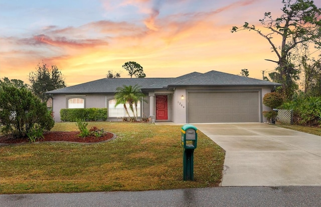 view of front of property with a garage and a yard