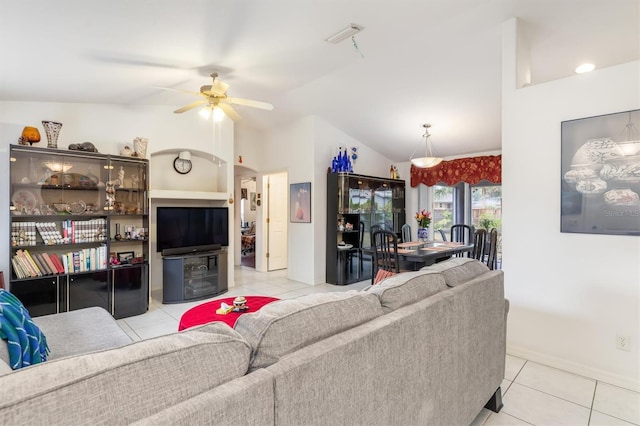 tiled living room featuring ceiling fan and vaulted ceiling