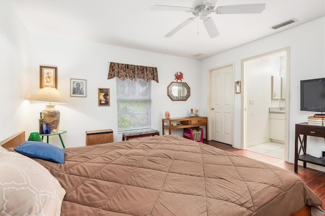 bedroom with ensuite bath, light hardwood / wood-style floors, and ceiling fan