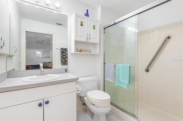 bathroom with vanity, a shower with shower door, tile patterned floors, and toilet