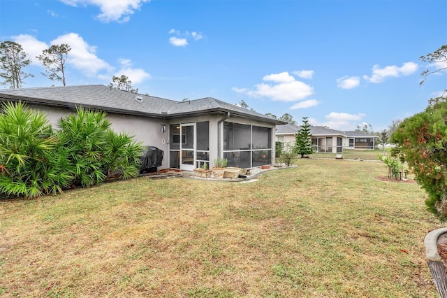 rear view of house with a yard and a sunroom