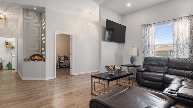 living room with a notable chandelier and light hardwood / wood-style floors