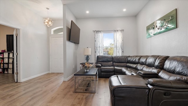 living room featuring light wood-type flooring and a notable chandelier