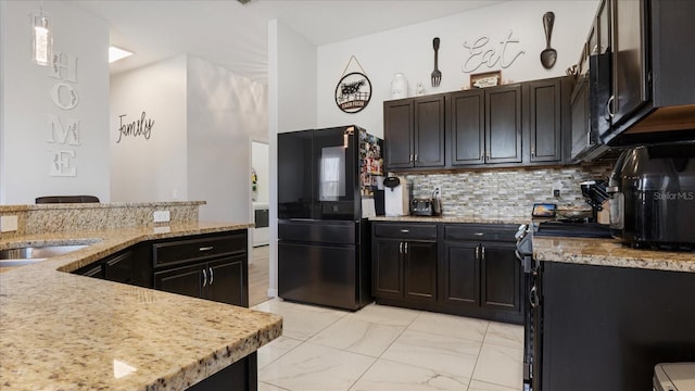 kitchen with black appliances, light stone countertops, decorative backsplash, and pendant lighting