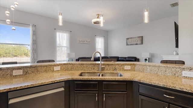 kitchen featuring stainless steel dishwasher, sink, pendant lighting, and dark brown cabinets