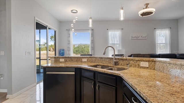 kitchen featuring sink, light stone countertops, and decorative light fixtures