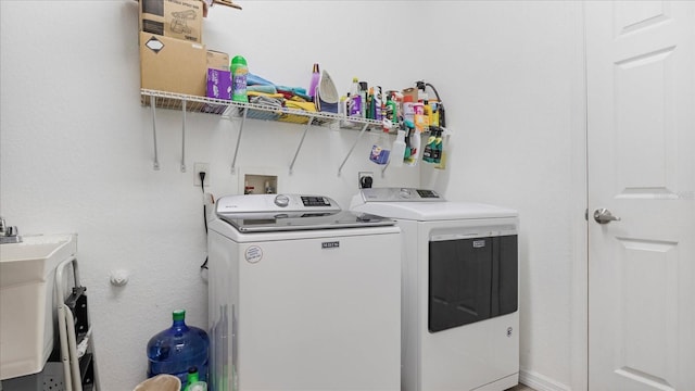 laundry area with independent washer and dryer and sink