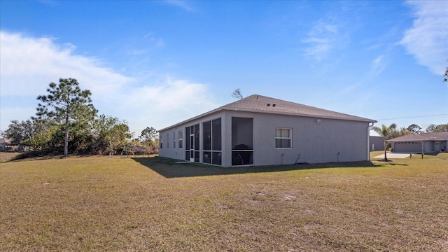 back of property with a yard and a sunroom