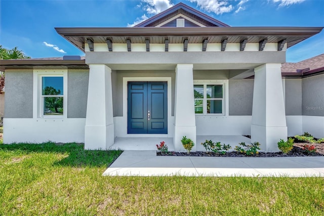 entrance to property with a porch and a lawn