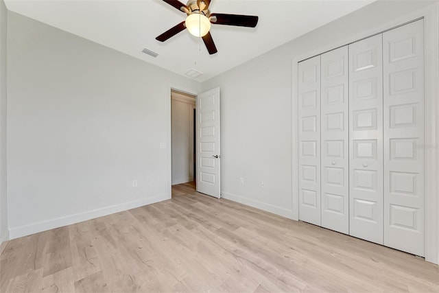 unfurnished bedroom featuring light hardwood / wood-style floors, ceiling fan, and a closet