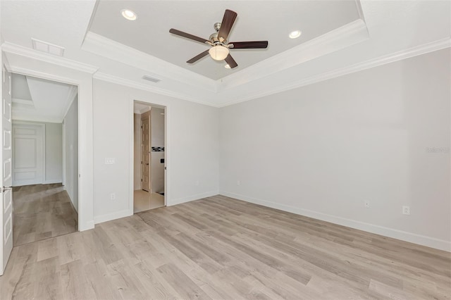 unfurnished room featuring crown molding, ceiling fan, a tray ceiling, and light hardwood / wood-style flooring