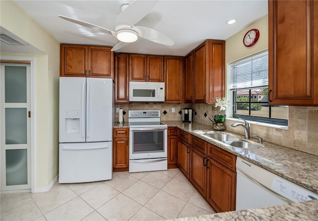 kitchen with sink, light stone counters, white appliances, tasteful backsplash, and ceiling fan