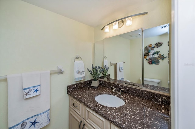 bathroom featuring vanity and toilet