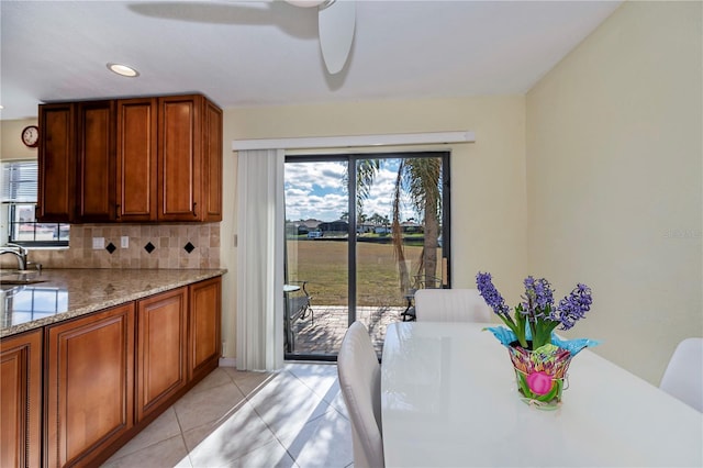 dining room with sink, light tile patterned floors, and ceiling fan