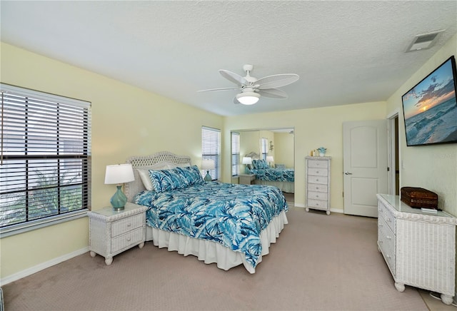 carpeted bedroom with a textured ceiling and ceiling fan