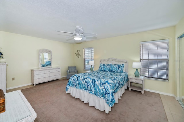 bedroom featuring carpet floors, a textured ceiling, and ceiling fan