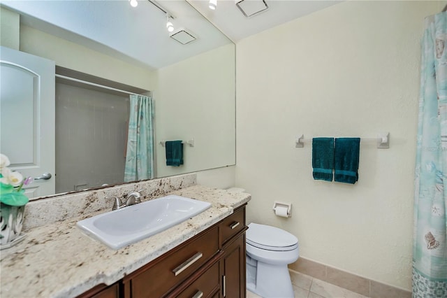 bathroom featuring tile patterned flooring, vanity, and toilet