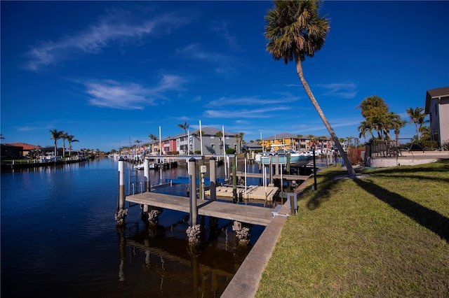 dock area with a water view and a lawn