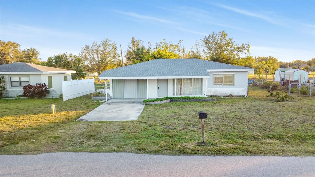 ranch-style home with a carport and a front lawn