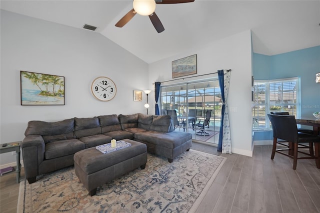 living room featuring ceiling fan, vaulted ceiling, and wood-type flooring