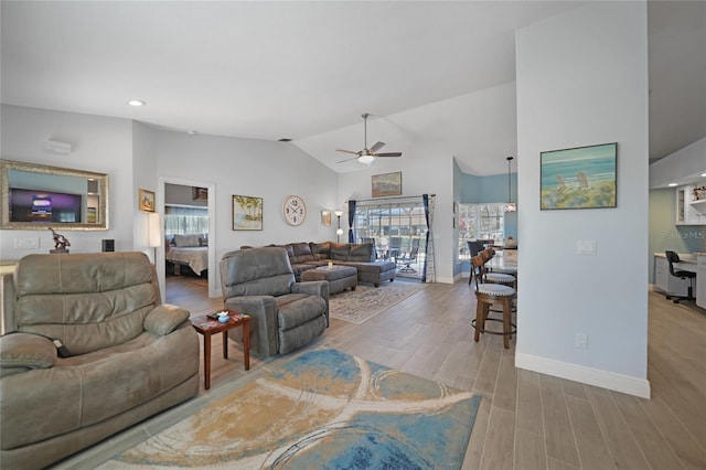 living room featuring ceiling fan, lofted ceiling, and light wood-type flooring