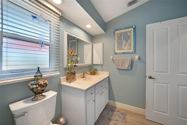 bathroom featuring lofted ceiling, toilet, wood-type flooring, and vanity