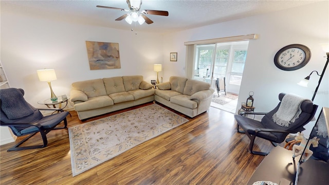 living room featuring wood-type flooring and ceiling fan