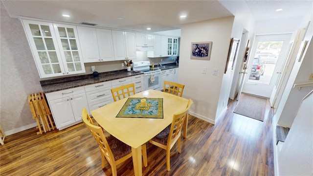 kitchen featuring wood-type flooring, white electric range oven, and white cabinets