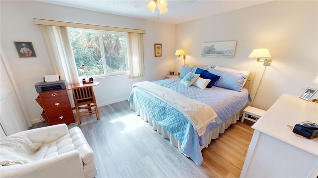 bedroom with ceiling fan and light hardwood / wood-style floors