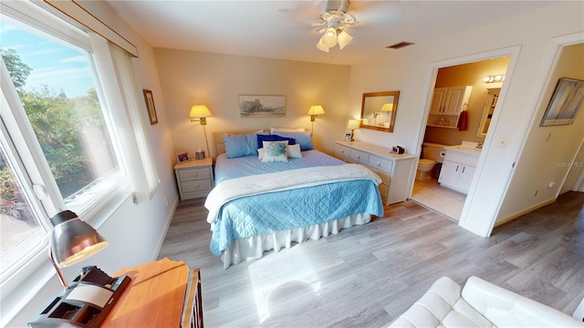 bedroom with ceiling fan, ensuite bathroom, and light hardwood / wood-style flooring