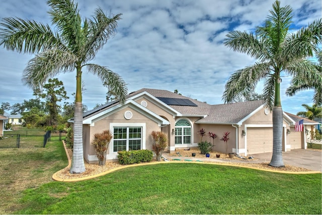 ranch-style home featuring a garage, a front lawn, and solar panels