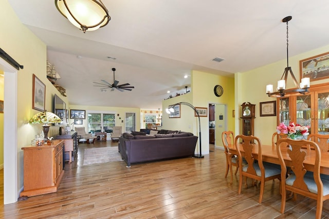 dining area featuring ceiling fan with notable chandelier and light hardwood / wood-style flooring