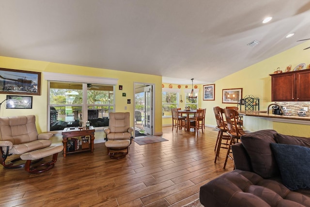 living room featuring wood-type flooring and vaulted ceiling