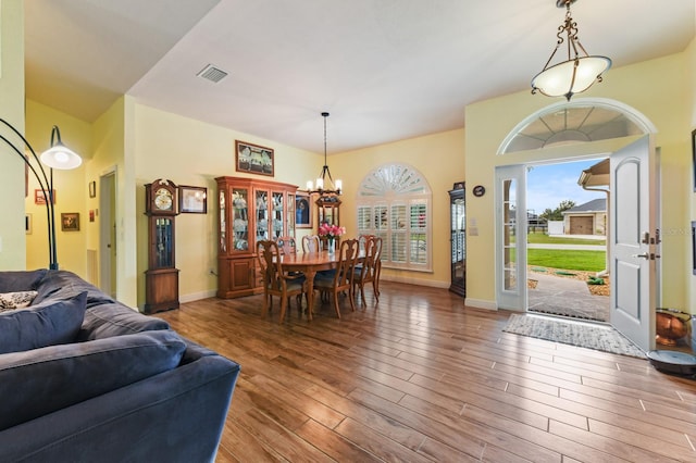 dining area with hardwood / wood-style floors and a notable chandelier