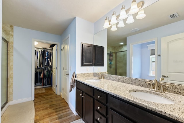 bathroom featuring hardwood / wood-style flooring, vanity, and a shower with door