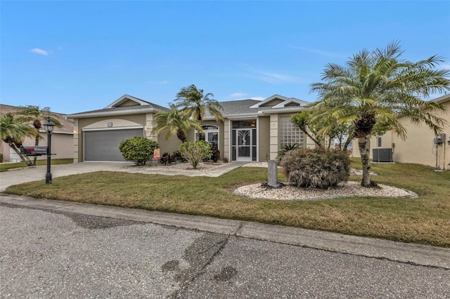 ranch-style house featuring central AC unit, a garage, and a front yard