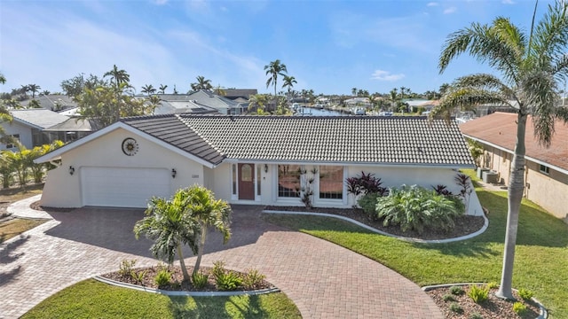 single story home with a water view, a garage, and a front yard